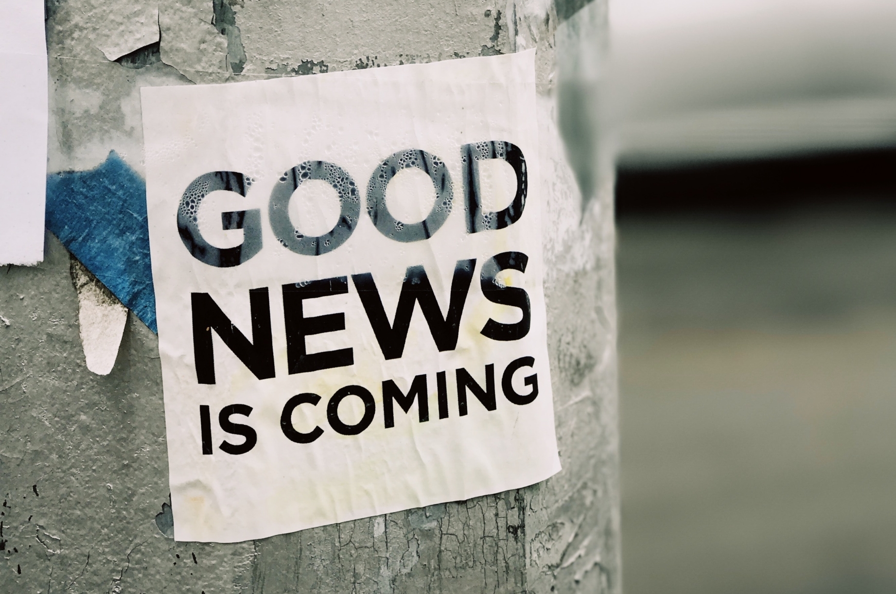 white Good News Is Coming paper on wall