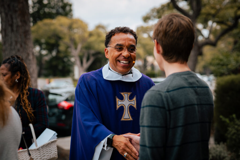 Pastor John Nunes shakes the hand of a parishioner